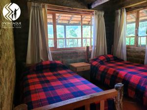 two beds in a room with two windows at Monzaque- paraíso de bachué in El Barrial