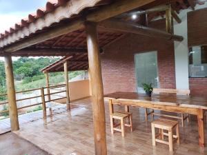 a room with a wooden table and chairs on a patio at Chácara do Picapau Amarelo in Socorro
