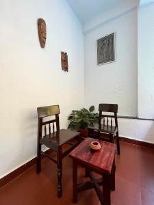 2 sillas y una mesa en una habitación en Namaste Jungle - A Boutique Homestay en Assagao