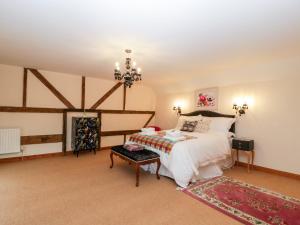 1 dormitorio con cama y lámpara de araña en The Granary, en Chepstow