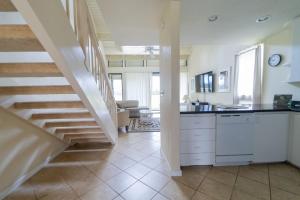 a kitchen with a staircase and a living room at Bird of Paradise Condo in Kahuku