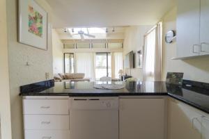 a kitchen with a counter top and a living room at Bird of Paradise Condo in Kahuku