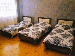 3 Betten in einem Zimmer mit einer Wand in der Unterkunft Gabala red villa in Qəbələ