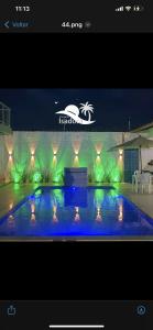 una imagen de una piscina con luces verdes en Isadora Pousada en Salinópolis