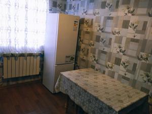 Zimmer mit einem Kühlschrank, einem Tisch und einem Fenster in der Unterkunft Gabala red villa in Qəbələ