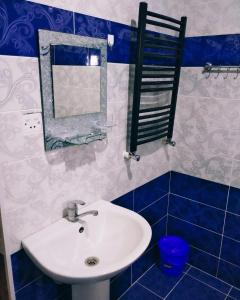 ein Bad mit einem Waschbecken und einem Spiegel in der Unterkunft Gabala red villa in Qəbələ