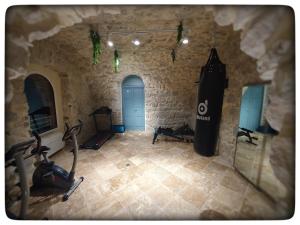 a gym with exercise equipment in a stone building at Le Vallaya Suites & Spa in Menton