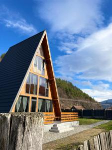 una pequeña casa con techo negro en Hidden Cabin, en Brezoi