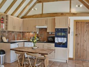 a kitchen with a wooden table and chairs at The Old Packhouse in Steyning