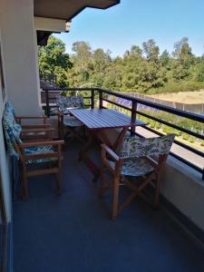 een tafel en stoelen op een balkon met uitzicht bij Departamento Condominio Los Castaños de Alicura Pucón in Pucón