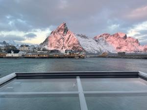 a view of a mountain from the back of a boat at Rostad Retro Rorbuer in Reine