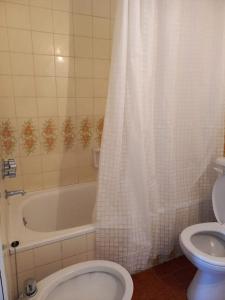 a bathroom with a toilet and a tub and a sink at Departamentos Alfonsina, a 3 cuadras del mar en La Perla in Mar del Plata