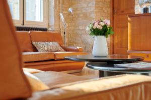 un soggiorno con un vaso di fiori su un tavolo di Maison Laroze a Gevrey-Chambertin