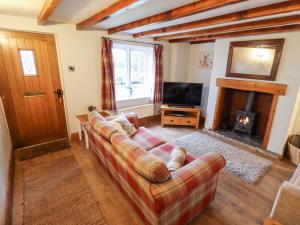 a living room with a couch and a fireplace at Thames Cottage in Hull