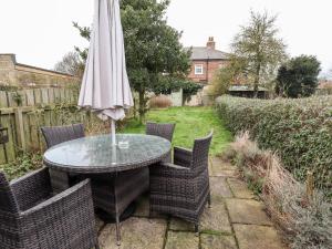 a table and chairs with an umbrella on a patio at Thames Cottage in Hull