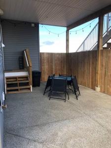 a patio with a table and chairs and a fence at Immaculate suite with amazing mountain views! in Cumberland
