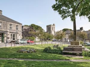 a park with a bench and a building with a church at Plover Cottage in Sharperton