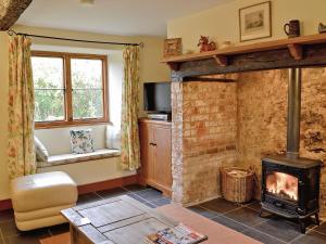 a living room with a fireplace and a stove at Blackberie Cottage - E2389 in Stoke Abbott