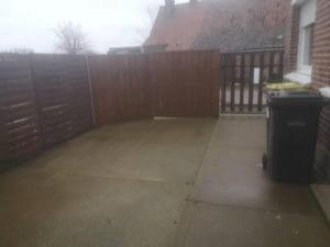 a patio with a fence and a trash can at Gîte chez Danielle in Blessy