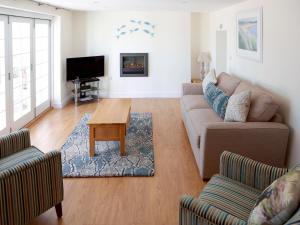 a living room with a couch and a table at Manor Cottage in Crantock