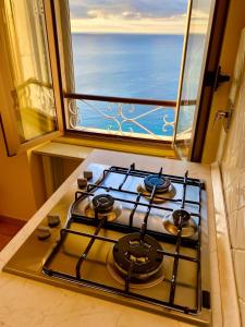 a stove top oven in a kitchen with a window at Kiss of sea - Balzi Rossi & Baia Beniamin in Ventimiglia