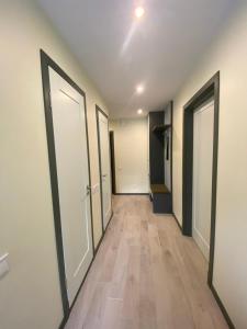 pusty korytarz z drzwiami i drewnianą podłogą w obiekcie Apartments in Kauguri w Jurmale