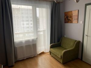 sala de estar con silla y ventana en Apartments in Kauguri en Jūrmala