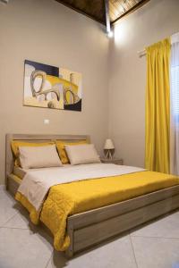 1 dormitorio con 1 cama grande con manta amarilla en Garden house en Neápolis