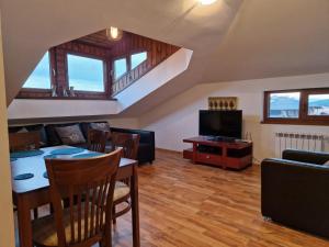 a living room with a table and a couch and a television at Mountain View Resort - Apartment B45 in Bansko