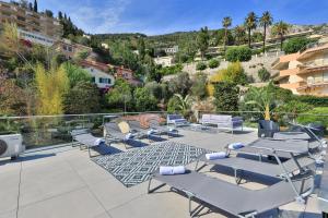 a group of lounge chairs and tables on a patio at Le Vallaya Suites & Spa in Menton