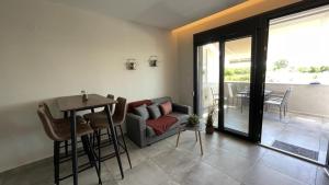 a living room with a couch and a table at Thalassa Apartment in Nea Peramos