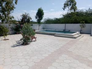 Poundiougne的住宿－Maison de Vacances à Foundiougne, Sénégal，后院设有游泳池和围栏