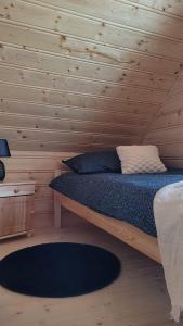 een slaapkamer met een bed met een houten muur bij Hamajdówka in Zubrzyca Górna