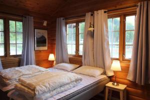 a bedroom with a bed in a room with windows at Trollstigen Resort in Åndalsnes