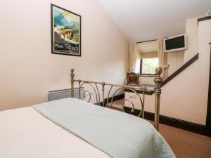 a bedroom with a bed and a staircase at Harry Eyre Cottage in Castleton