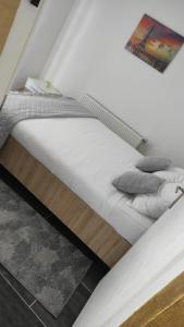 Imperial exclusive apartments في فليكا كلادوشا: سرير بشرشف ووسائد بيضاء في الغرفة