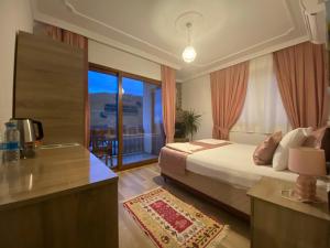 a hotel room with a bed and a balcony at Faralya Misafir Evi in Faralya