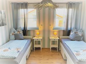 2 Betten in einem Zimmer mit 2 Fenstern in der Unterkunft Haus-Am-See-Pratzschwitz in Pirna