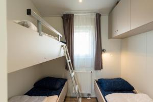 een slaapkamer met 2 stapelbedden en een ladder bij waddenlief in Ballum
