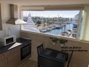 a kitchen with a window with a view of a marina at Puerto Marina waterfront apartment in Benalmádena