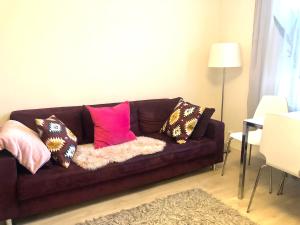 a brown couch with pillows on it in a living room at Scandinavian Desing Home 37 City Center in Kamppi in Helsinki