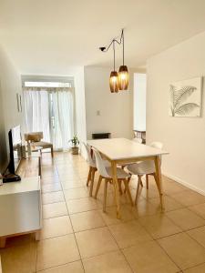 a dining room and living room with a table and chairs at Chic Apartment Cañada in Córdoba