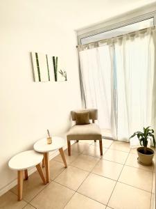 a living room with a chair and a table at Chic Apartment Cañada in Córdoba