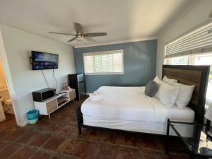 a bedroom with a white bed and a flat screen tv at Sand Castle in Imperial Beach