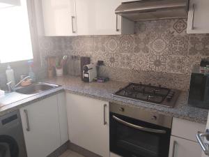 uma cozinha com fogão forno ao lado de um lavatório em Appartement de luxe Prestigia Opale 