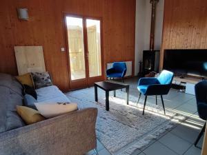 un soggiorno con divano, sedie e TV di Chalet calme 3 ch a Sanguinet