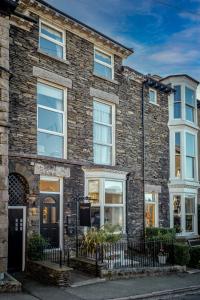 a brick house with white windows and a fence at Lingmoor in Windermere