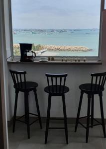 ラ・リベルターにあるLibertad 109 Hotelの海の景色を望むカウンターと椅子2脚