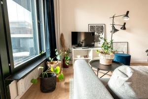 a living room with a couch and potted plants at 2ndhomes Cozy high-quality Studio in Kluuvi with Balcony in Helsinki