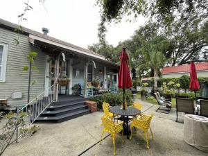 une terrasse avec une table, des chaises et un parasol dans l'établissement Bywater Home, Parking and Pet Friendly Retreat, à La Nouvelle-Orléans